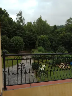 a wrought iron fence with a view of a garden at Apartament Przy Skale u Anny in Sąspów