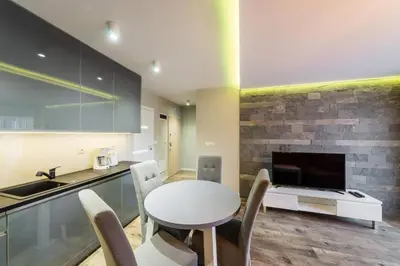 a kitchen with a white table and chairs and a fireplace at Apartament Rakowicka 14 Deluxe Old Town WAWELOFTS in Kraków
