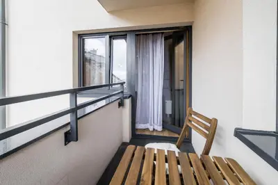 a wooden bench sitting in front of a window at Apartament Rakowicka 14 Deluxe Old Town WAWELOFTS in Kraków