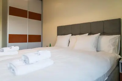 a large white bed with two white towels on it at Apartament Rakowicka 14 Deluxe Old Town WAWELOFTS in Kraków