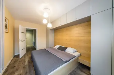 a bedroom with a bed with a wooden wall at Apartament Rakowicka 14 Deluxe Old Town WAWELOFTS in Kraków