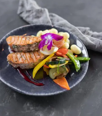 a plate of food with fish and vegetables on a table at JJ Sport Concept Hotel in Kraków