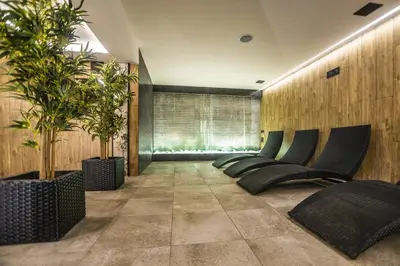 a lobby with a row of chairs and trees at JJ Sport Concept Hotel in Kraków