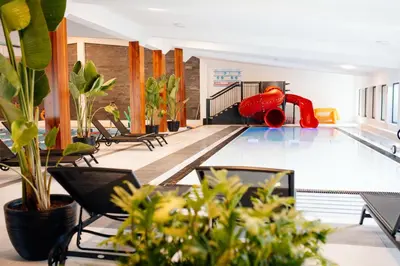 a swimming pool with a red slide in the middle at JJ Sport Concept Hotel in Kraków