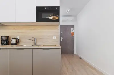 a kitchen with a sink and a microwave at Apartments Kraków Rajska 3 by Noclegi Renters in Kraków