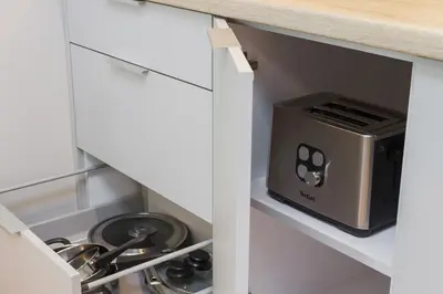 a kitchen with a toaster oven sitting in a drawer at Apartments Kraków Rajska 3 by Noclegi Renters in Kraków