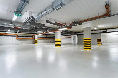 an empty parking garage with white floors and columns at Apartments Kraków Rajska 3 by Noclegi Renters in Kraków