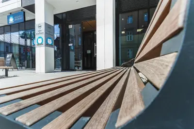 a shadow of a bench in front of a building at Apartments Kraków Rajska 3 by Noclegi Renters in Kraków