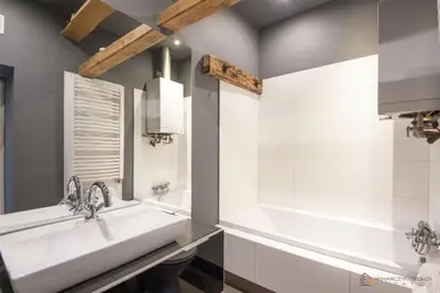 a bathroom with a white tub and a sink at Własny Pokój in Kraków