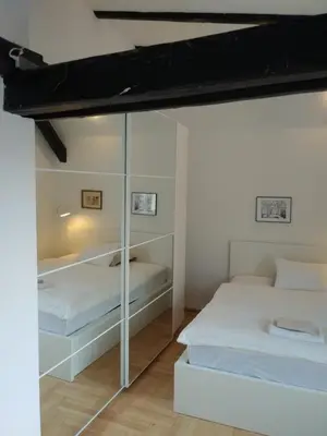 a bedroom with two beds and a glass wall at Własny Pokój in Kraków
