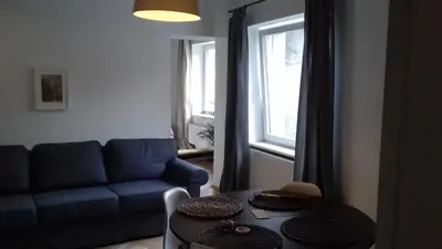 a living room with a blue couch and a table at Własny Pokój in Kraków