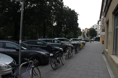 a row of cars parked on a street with bikes at Apartament Daszyńskiego in Kraków