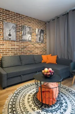 a living room with a couch and a table at Orange, modern apartment in the city centre in Kraków