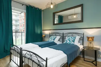 a bedroom with two beds and a mirror at Orange, modern apartment in the city centre in Kraków