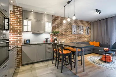 a kitchen and living room with a table and chairs at Orange, modern apartment in the city centre in Kraków