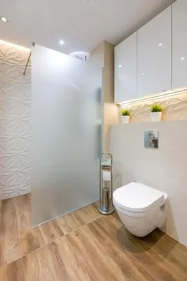 a bathroom with a white toilet in a room at Orange, modern apartment in the city centre in Kraków