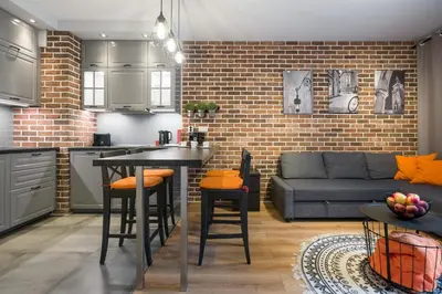 a kitchen and living room with a couch and a table at Orange, modern apartment in the city centre in Kraków