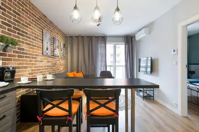 a kitchen with a large black table with chairs at Orange, modern apartment in the city centre in Kraków
