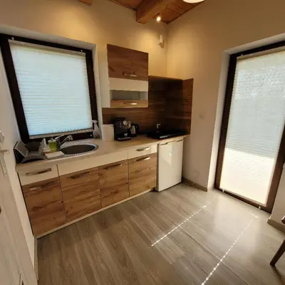 a kitchen with a sink and a large window at Na Szlaku - domki do wynajęcia in Rabka
