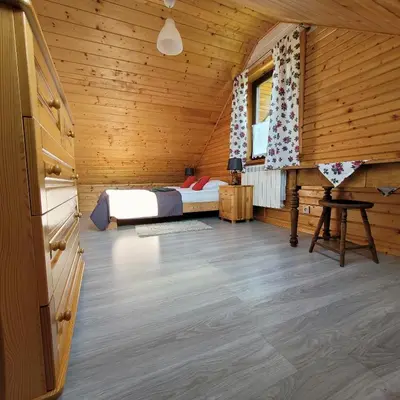 a bedroom with a bed in a wooden cabin at Na Szlaku - domki do wynajęcia in Rabka