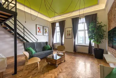 a living room with a couch and a staircase at City Vibes Apartments in Kraków