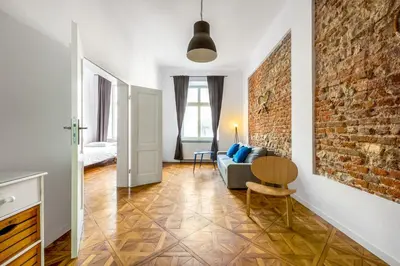 a living room with a couch and a brick wall at City Vibes Apartments in Kraków