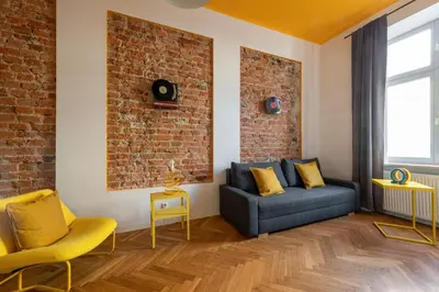 a living room with a blue couch and a brick wall at City Vibes Apartments in Kraków