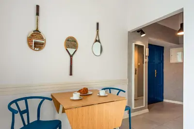a dining room with a table and chairs and a blue door at City Vibes Apartments in Kraków