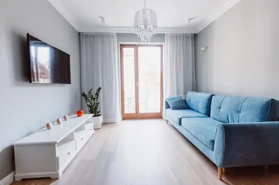 a living room with a blue couch and a tv at Exclusive 