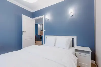 a blue bedroom with a white bed and a blue wall at Exclusive 
