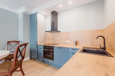 a kitchen with blue cabinets and a sink and a table at Exclusive 