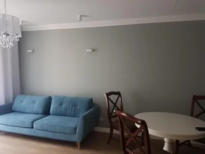 a living room with a blue couch and a table at Exclusive 