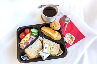 a black plate of food with a cup of coffee at AirPark Balice in Balice