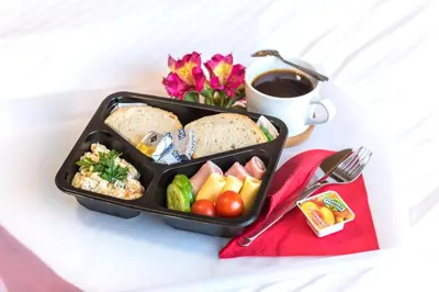 a lunch box with bread and vegetables and a cup of coffee at AirPark Balice in Balice