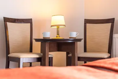 a table with two chairs and a lamp on it at AirPark Balice in Balice
