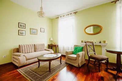 a living room with a couch and a table and chairs at 100% cracovian traditional apartment in Kraków