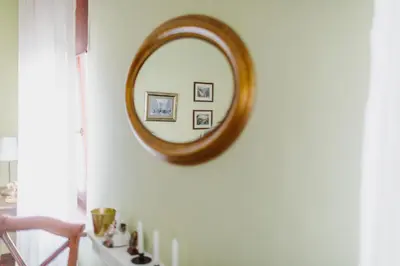 a mirror on a white wall in a room at 100% cracovian traditional apartment in Kraków
