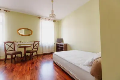 a bedroom with a bed and a table with chairs at 100% cracovian traditional apartment in Kraków