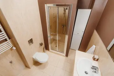 a bathroom with a toilet sink and a shower at 100% cracovian traditional apartment in Kraków