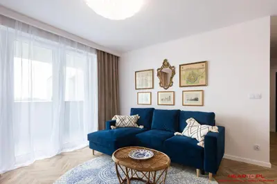 a blue couch in a living room with a table at Apartments Nearto Old Town Vermelo in Kraków