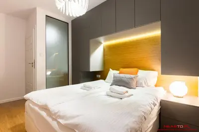a bedroom with a large white bed with towels on it at Apartments Nearto Old Town Vermelo in Kraków