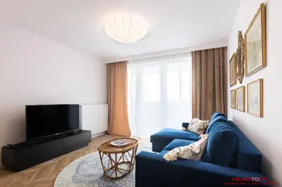 a living room with a blue couch and a tv at Apartments Nearto Old Town Vermelo in Kraków