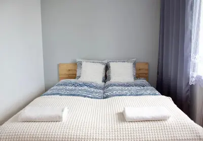 a bedroom with a bed with two pillows on it at Apartamenty ZORZA in Kraków
