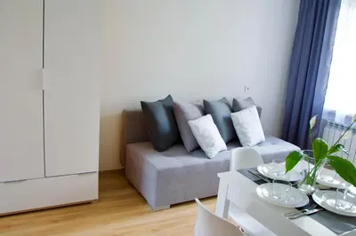 a living room with a couch and a table at Apartamenty ZORZA in Kraków