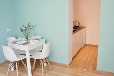 a dining room with a white table and chairs at Apartamenty ZORZA in Kraków