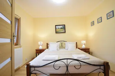 a bedroom with a large bed with two night stands at Domek Anielski in Zator