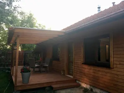 a deck with a table and chairs on a house at Domek Anielski in Zator