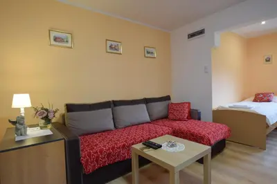 a living room with a couch and a bed at Domek Anielski in Zator