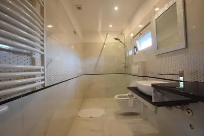 a white bathroom with a sink and a toilet at Domek Anielski in Zator