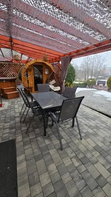 a patio with a table and chairs under a roof at Agroturystyka U Misia in Niedźwiedź